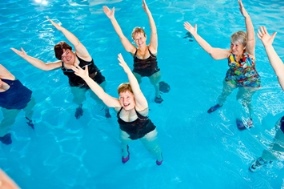 Grupo de mujeres mayores haciendo ejercicio en la piscina.