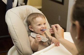 ni&ntilde;o comiendo en una trona