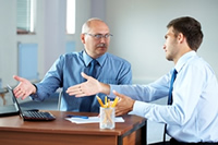 Dos hombres discutiendo en una reunión de trabajo.